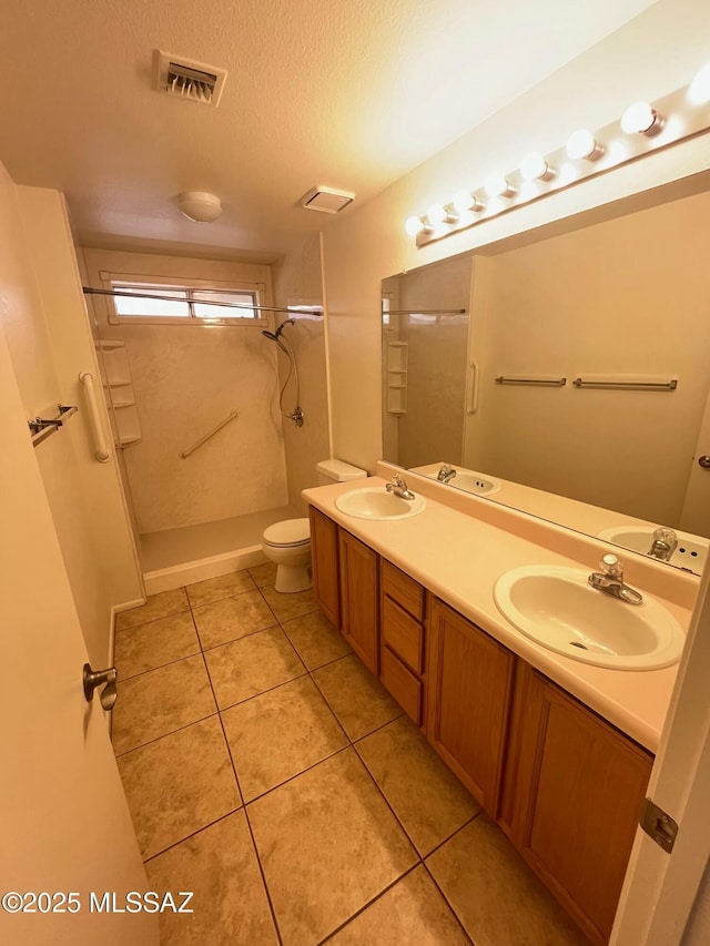 full bathroom with tile patterned floors, visible vents, toilet, a sink, and a textured ceiling