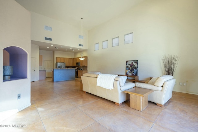 tiled living room featuring a towering ceiling