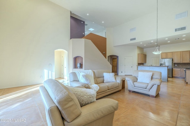 tiled living room featuring a high ceiling