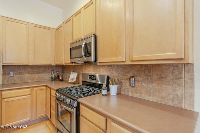 kitchen with tasteful backsplash, stainless steel appliances, and light brown cabinets