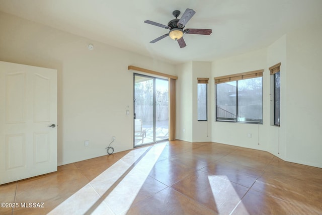 tiled spare room featuring ceiling fan