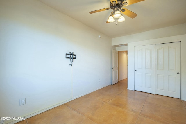 unfurnished bedroom with light tile patterned floors, ceiling fan, and a closet