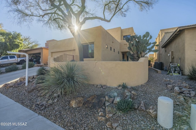 view of property exterior with central AC and a carport