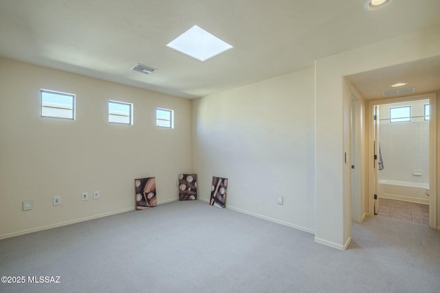 carpeted spare room with a skylight and a healthy amount of sunlight