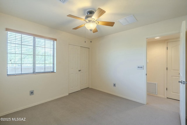 unfurnished bedroom featuring light carpet, ceiling fan, and a closet