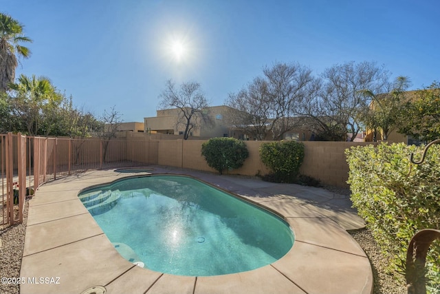 view of swimming pool featuring a patio and a jacuzzi