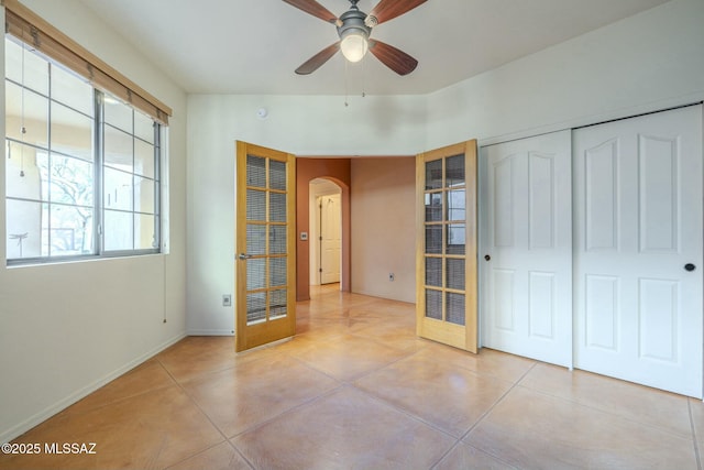 unfurnished bedroom with light tile patterned flooring, ceiling fan, and a closet