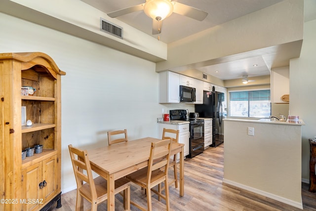 dining space with visible vents, ceiling fan, light wood-style flooring, and baseboards