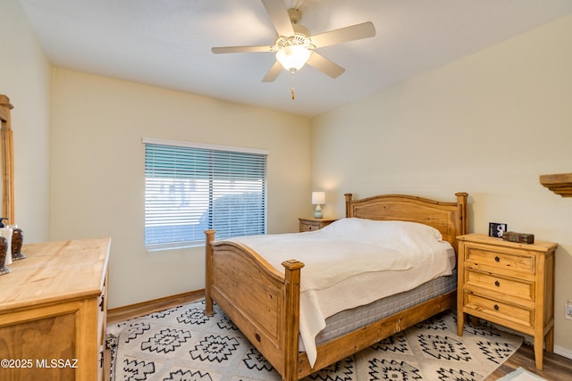 bedroom featuring light wood-type flooring, baseboards, and a ceiling fan