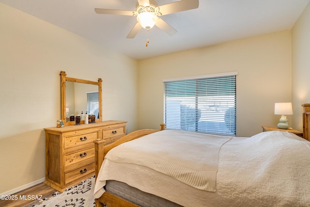 bedroom with light wood finished floors, ceiling fan, and baseboards