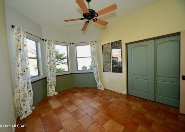 unfurnished bedroom featuring a closet, tile patterned floors, and ceiling fan