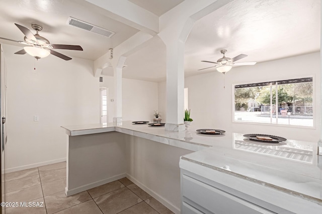 kitchen with ceiling fan, kitchen peninsula, and light tile patterned floors