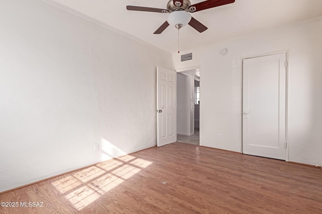 unfurnished bedroom featuring crown molding, wood-type flooring, and ceiling fan