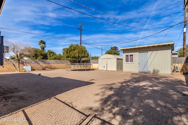 view of yard featuring a trampoline and a storage shed