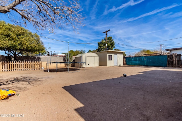 view of yard with a trampoline and a shed