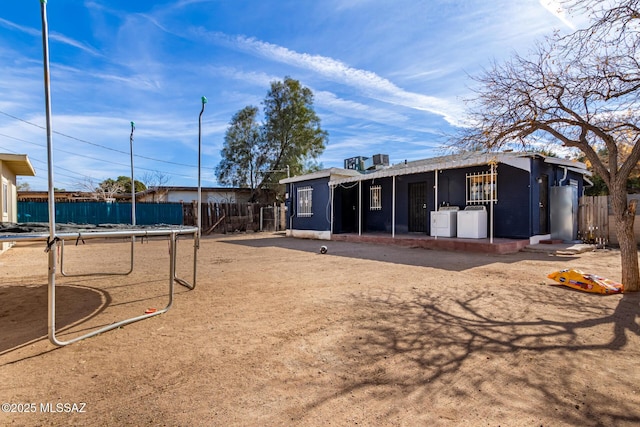 back of property with separate washer and dryer and a trampoline