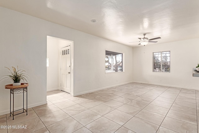 tiled spare room featuring ceiling fan