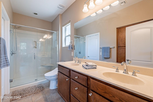 bathroom featuring tile patterned flooring, toilet, a shower with door, and vanity