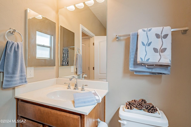 bathroom with curtained shower, toilet, and vanity