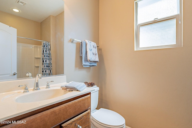 bathroom featuring toilet, walk in shower, and vanity