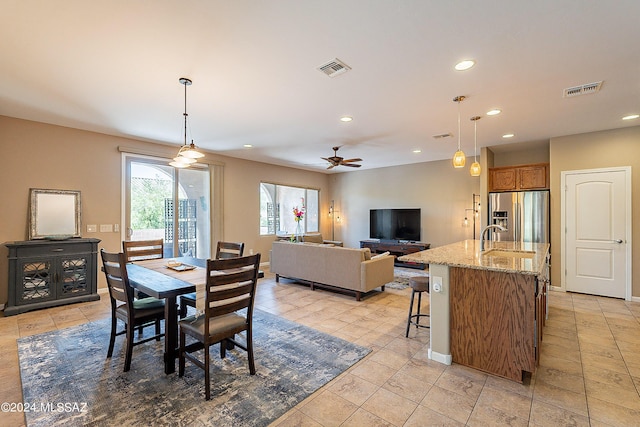 tiled dining room with sink and ceiling fan