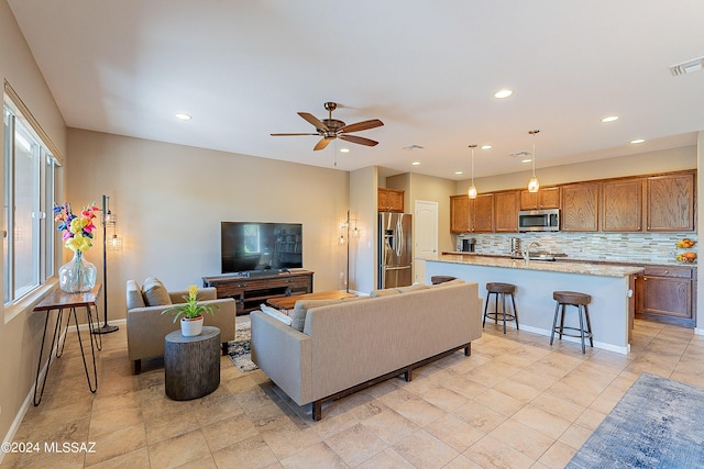 living room with ceiling fan and sink