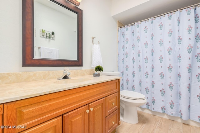 bathroom featuring vanity, hardwood / wood-style flooring, a shower with curtain, and toilet