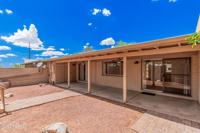 rear view of property featuring ceiling fan and a patio