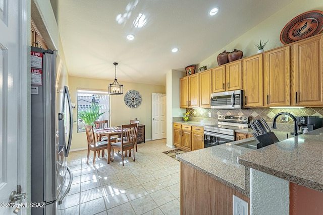 kitchen featuring appliances with stainless steel finishes, sink, decorative backsplash, hanging light fixtures, and light stone counters