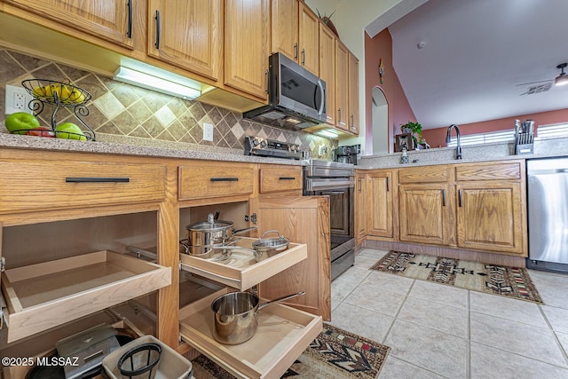 kitchen with backsplash, light tile patterned flooring, sink, and appliances with stainless steel finishes