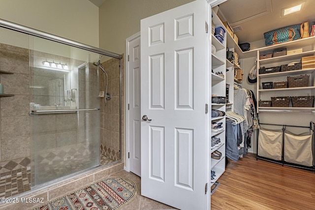 bathroom featuring wood-type flooring and a shower with shower door