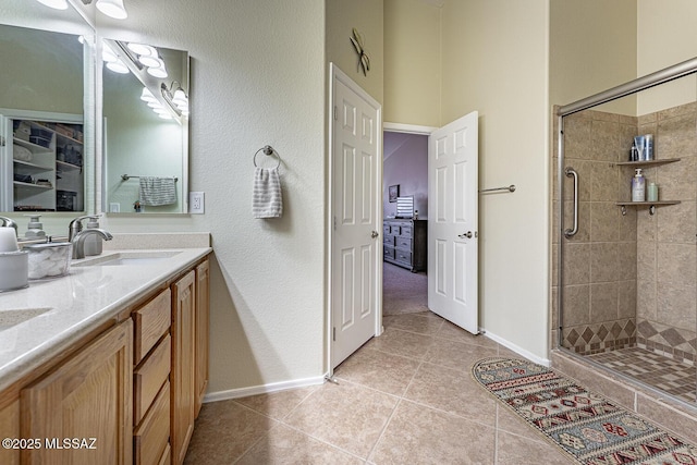 bathroom with tile patterned flooring, vanity, and a shower with door