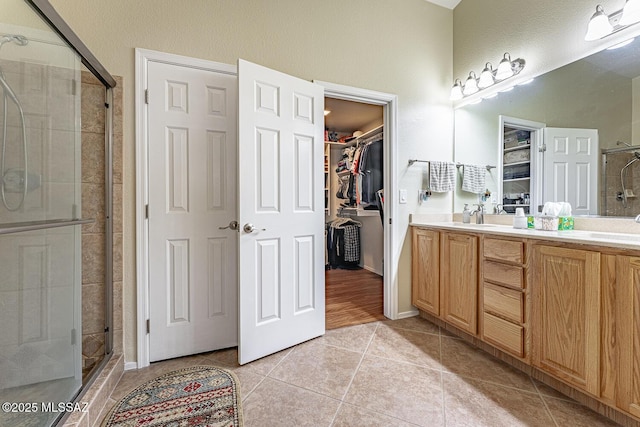 bathroom featuring tile patterned flooring, vanity, and walk in shower