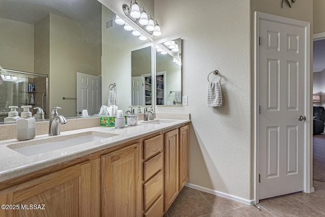 bathroom featuring vanity, a shower with shower door, and tile patterned flooring