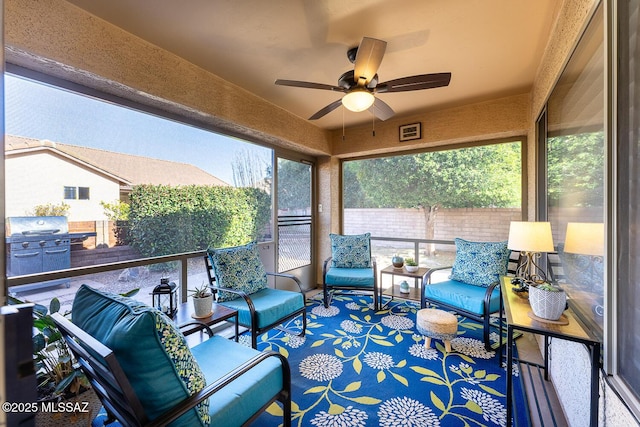 sunroom / solarium featuring ceiling fan