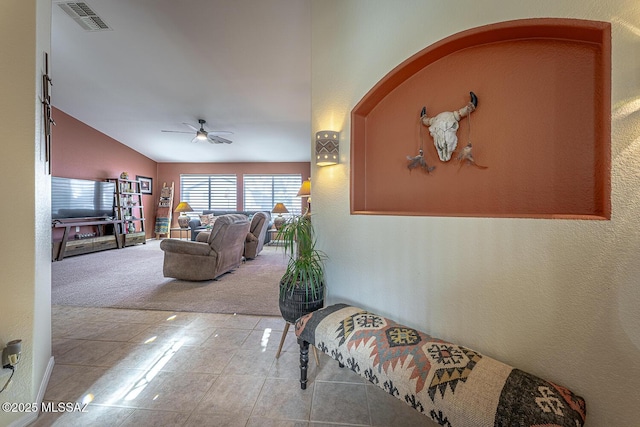 carpeted living room featuring vaulted ceiling and ceiling fan