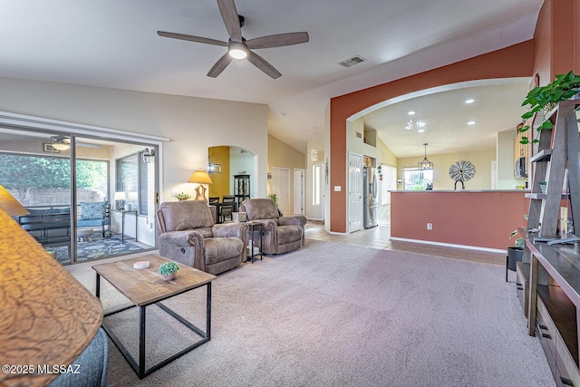 carpeted living room with ceiling fan and lofted ceiling