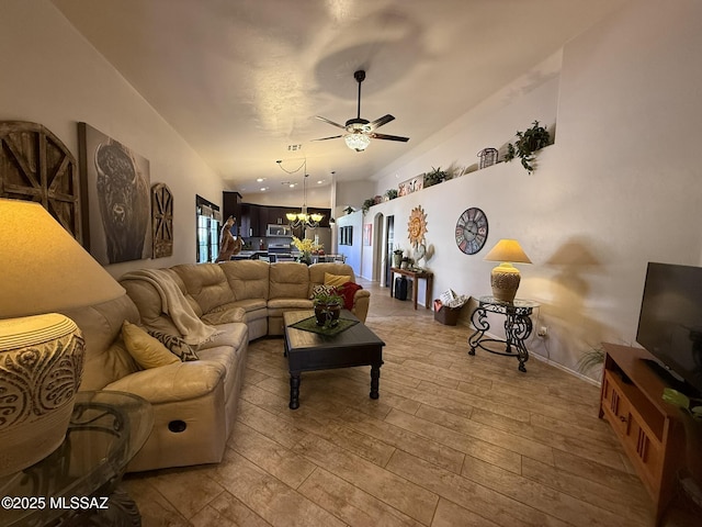 living room with light wood-type flooring and ceiling fan with notable chandelier