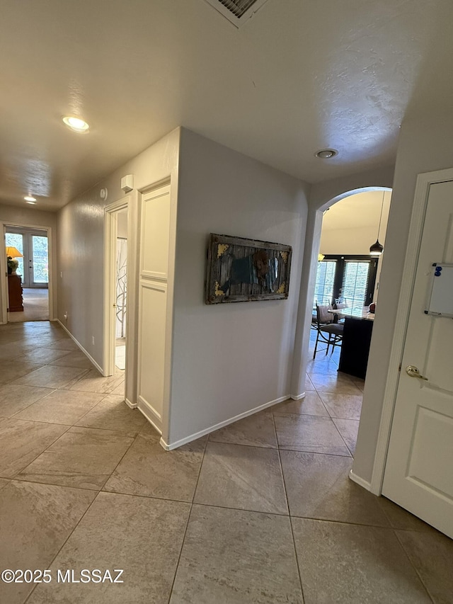 corridor with a wealth of natural light and light tile patterned flooring