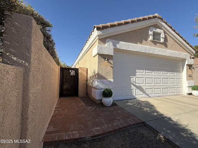 exterior space with a garage and a wall unit AC