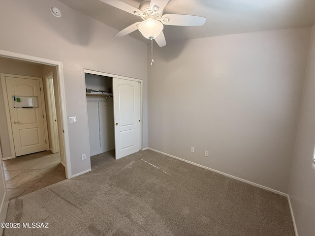 unfurnished bedroom featuring ceiling fan, a closet, lofted ceiling, and carpet flooring