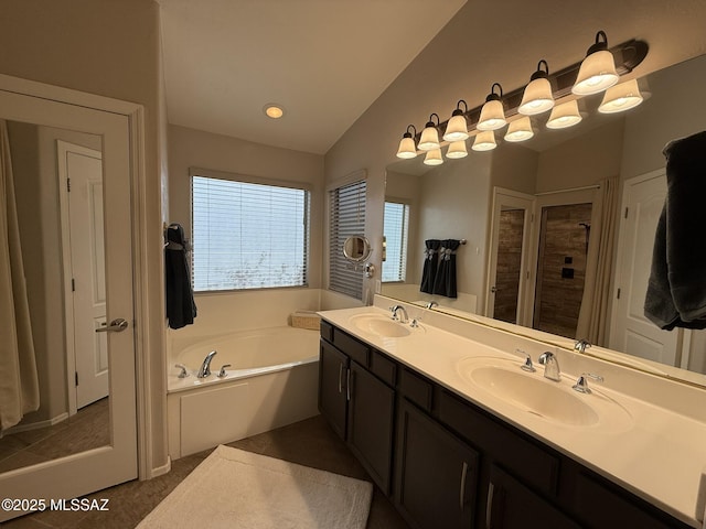 bathroom featuring a bathing tub, lofted ceiling, and vanity