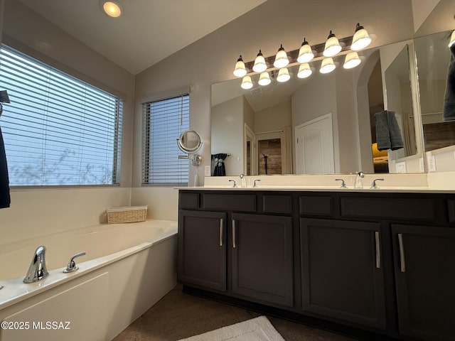 bathroom featuring vanity, lofted ceiling, a bath, and tile patterned flooring