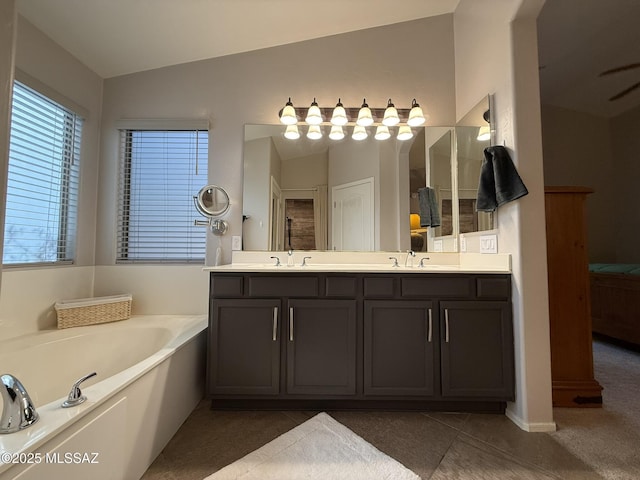 bathroom with vanity, vaulted ceiling, a bath, and tile patterned flooring