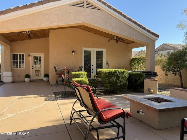 view of patio featuring ceiling fan, an outdoor fire pit, and french doors