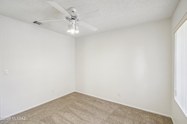 empty room with ceiling fan, carpet flooring, and a textured ceiling