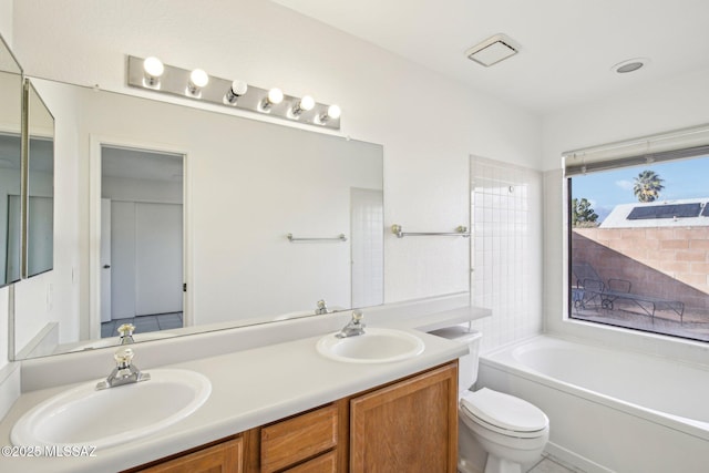 bathroom featuring toilet, vanity, and a bath