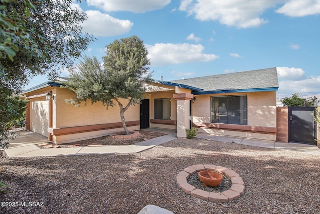 view of front of property with a garage and a fire pit