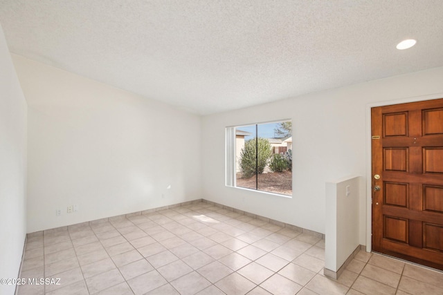 tiled spare room featuring a textured ceiling