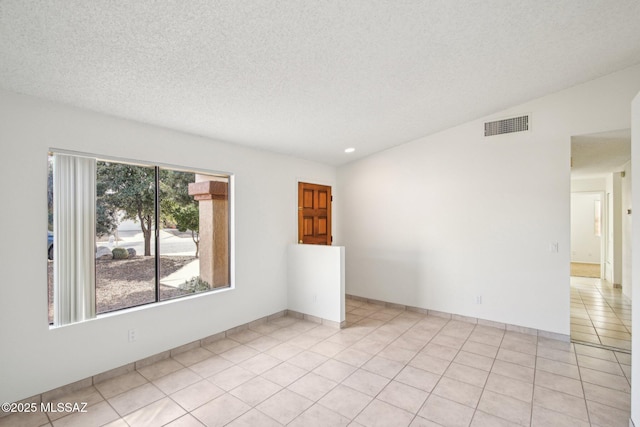 tiled spare room featuring a textured ceiling